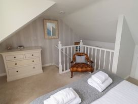 A bedroom with a bed and a dressing table at Marie's Cottage in Craster