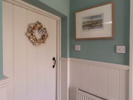 An entrance hall with a door and wreath at Marie's Cottage in Craster