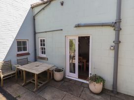 An outdoor seating area with a table and chairs at Marie's Cottage in Craster