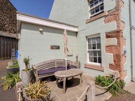 A seating area with a bench and table at Marie's Cottage in Craster