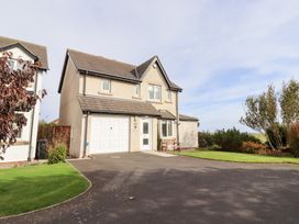 A house with a garage door and garden at Beach View in Seahouses