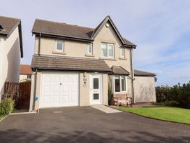 A house with a driveway and bench at Beach View in Seahouses