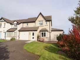 A house with a garage and bench in the front yard at Beach View in Seahouses