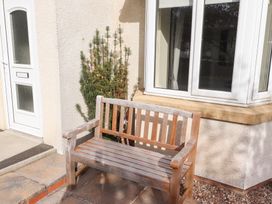 A bench beside a door and window at Beach View in Seahouses