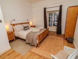 A bedroom with a bed, bedside tables and a wardrobe at Alnbank in Alnmouth