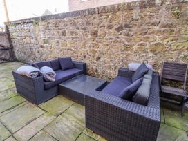 An outdoor seating area with sofas, a table, and a chair at Alnbank in Alnmouth