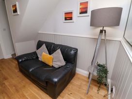 A living room with a sofa and lamp at Heather Cottages - Brent Goose in Bamburgh