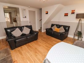 A living room with sofas and a table at Heather Cottages - Brent Goose in Bamburgh
