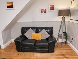 A living room with a sofa and lamp at Heather Cottages - Brent Goose in Bamburgh