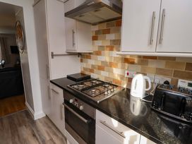 A kitchen with a gas stove and kettle at Heather Cottages - Brent Goose, Bamburgh