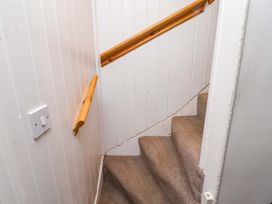A staircase with a handrail and light switch at Heather Cottages - Brent Goose in Bamburgh