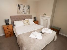 A bedroom with a bed and nightstands at Heather Cottages - Brent Goose Bamburgh