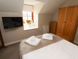A bedroom with a bed and a TV at Heather Cottages - Brent Goose in Bamburgh