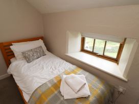 A bedroom with a single bed and window at Heather Cottages - Brent Goose in Bamburgh