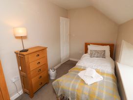 A bedroom with a single bed and dresser at Heather Cottages - Brent Goose in Bamburgh