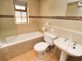 A bathroom with a bathtub, toilet, and sink at Heather Cottages - Brent Goose in Bamburgh