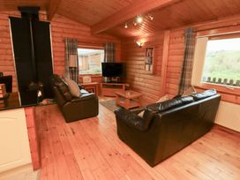 A living room with a sofa and television at Heather Cottages - Brown Owl Bamburgh