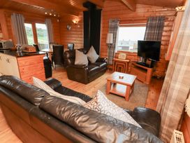 A living room with a sofa and a TV at Heather Cottages - Brown Owl in Bamburgh