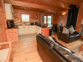 A kitchen and living area with wooden flooring at Heather Cottages - Brown Owl Bamburgh