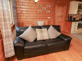 A living room with a sofa and kitchen units at Heather Cottages - Brown Owl in Bamburgh
