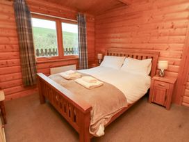 A bedroom with a bed and nightstands at Heather Cottages - Brown Owl in Bamburgh