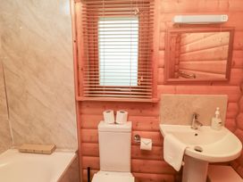 A bathroom with a bathtub, toilet, and sink at Heather Cottages - Brown Owl in Bamburgh