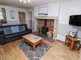 A living room with a fireplace and sofa at Heather Cottages - Godwit in Bamburgh