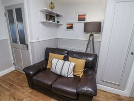 A living room with a sofa and a shelf at Heather Cottages - Godwit in Bamburgh