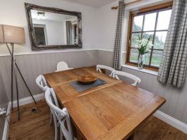 A dining room with a wooden table and chairs at Heather Cottages - Godwit in Bamburgh
