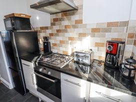 A kitchen with appliances including a refrigerator and gas stove at Heather Cottages - Godwit in Bamburgh