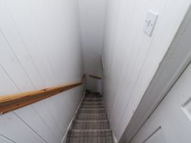A staircase with a handrail and a light switch at Heather Cottages - Godwit in Bamburgh