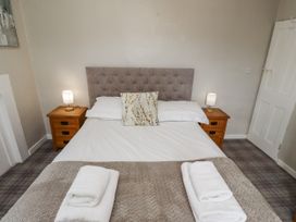 A bedroom with a bed and bedside tables at Heather Cottages - Godwit Bamburgh
