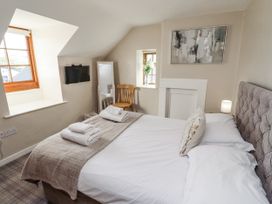 A bedroom with a bed and a television at Heather Cottages - Godwit in Bamburgh