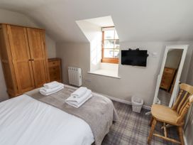 A bedroom with a bed and television at Heather Cottages - Godwit in Bamburgh