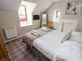 A bedroom with a bed and window at Heather Cottages - Godwit in Bamburgh