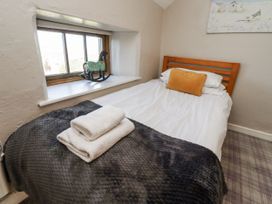 A bedroom with a bed and a window at Heather Cottages - Godwit in Bamburgh