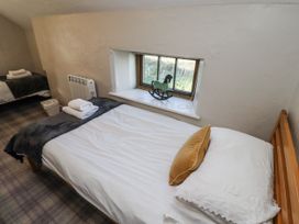A bedroom with a bed and a window at Heather Cottages - Godwit in Bamburgh