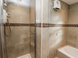 A shower and bath tub in a bathroom at Heather Cottages - Godwit in Bamburgh