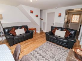 A living room with sofas and a table at Heather Cottages - Grayling in Bamburgh