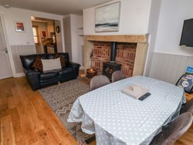 A living room with a sofa and table at Heather Cottages - Grayling in Bamburgh