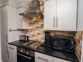 A kitchen with appliances and cabinets at Heather Cottages - Grayling in Bamburgh
