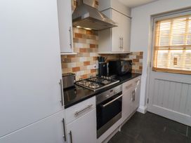 A kitchen with stove, oven, and microwave at Heather Cottages - Grayling in Bamburgh