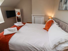 A bedroom with a bed and television at Heather Cottages - Grayling in Bamburgh