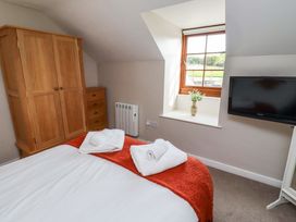 A bedroom with a bed and wardrobe at Heather Cottages - Grayling in Bamburgh