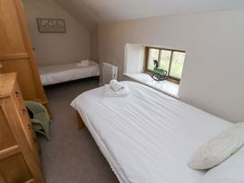 A bedroom with two beds and a window at Heather Cottages - Grayling in Bamburgh