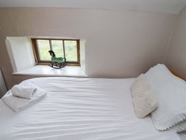 A bedroom with a bed and window at Heather Cottages - Grayling in Bamburgh