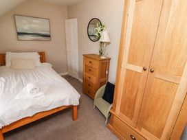 A bedroom with a bed and a wardrobe at Heather Cottages - Grayling in Bamburgh