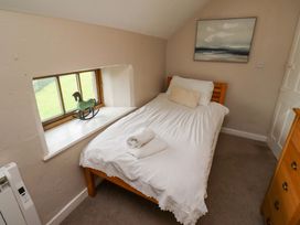 A bedroom with a single bed and window at Heather Cottages - Grayling in Bamburgh