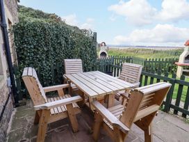A table with chairs in an outdoor area at Heather Cottages - Grayling in Bamburgh