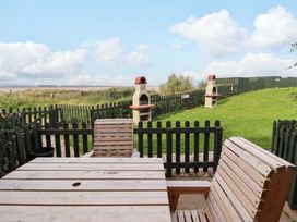 A garden with a table and chairs at Heather Cottages - Grayling in Bamburgh